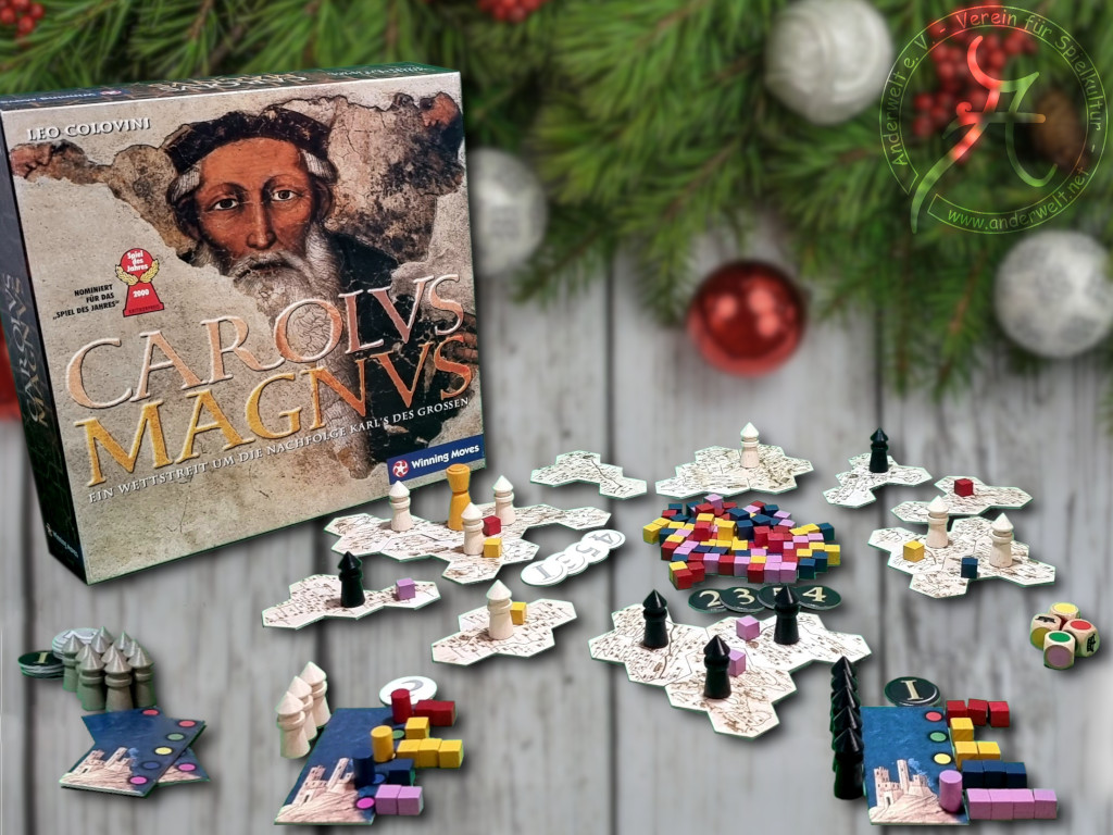 Viele kleine Türmchen, die sich auf getrennten Plättchen befinden. In der Mitte zahllose bunte Plättchen und im Hintergrund die Spielschachtel mit einer historischen Abbildung von Karl dem Großen.