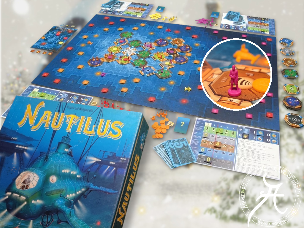Ein großer Spielplan, der eine Unterwasser-Stadt zeigt, mit vielen Plättchen, Figuren, und Spiel-Chips darauf. Drumherum ist weiteres Spielmaterial angesammelt wie Spiel-Scheine, Münzen und Bretter. Im Vordergrund der Spielkarton mit einem U-Bot (Typ Nautilus) darauf.