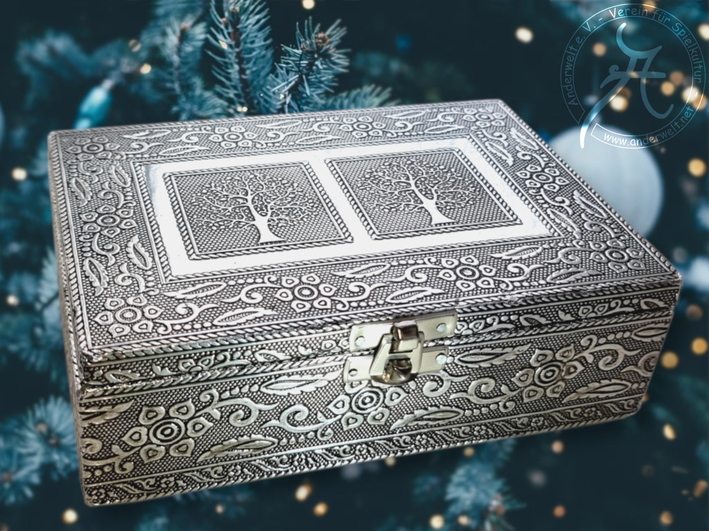 Silberfarbene Schatulle mit punzierten Blech, das Blätter, Blüten und Bäume zeigt.