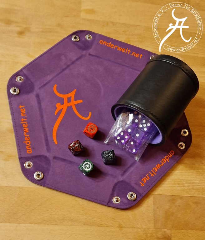 Das Bild zeigt einen violetten Würfelteller mit geöffneten Druckknöpfen und orangener Anderwelt-Beschriftung. Auf dem Teller liegen 2 W6 in orange und dunkelgrün, sowie 2 W10 in dunkelrot und schwarz - jeweils mit Anderwelt-Logo anstelle der höchsten Augenzahl. Daneben liegt ein schwarzer Leder-Würfelbecher mit violettem Innenfutter, aus dem ein eingeschweißtes Päckchen violetter W6 herausschaut.