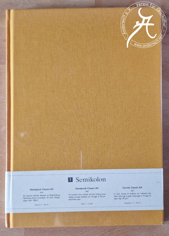 Das Bild zeigt die Vorderansicht des Notizbuchs. Eine weiße Banderole nennt den Hersteller und die wesentlichen Eigenschaften. Darüber befindet sich noch eine Shrinkwrap-Verpackung.