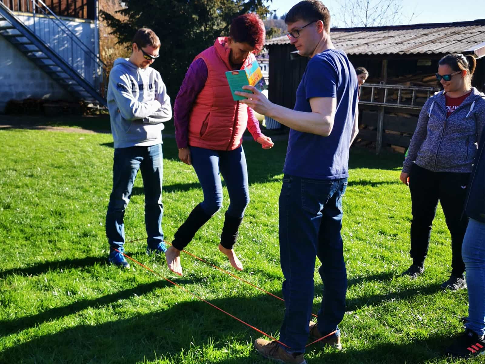 Ausgewachsene Menschen beim fröhlichen Springen über Gummibänder.