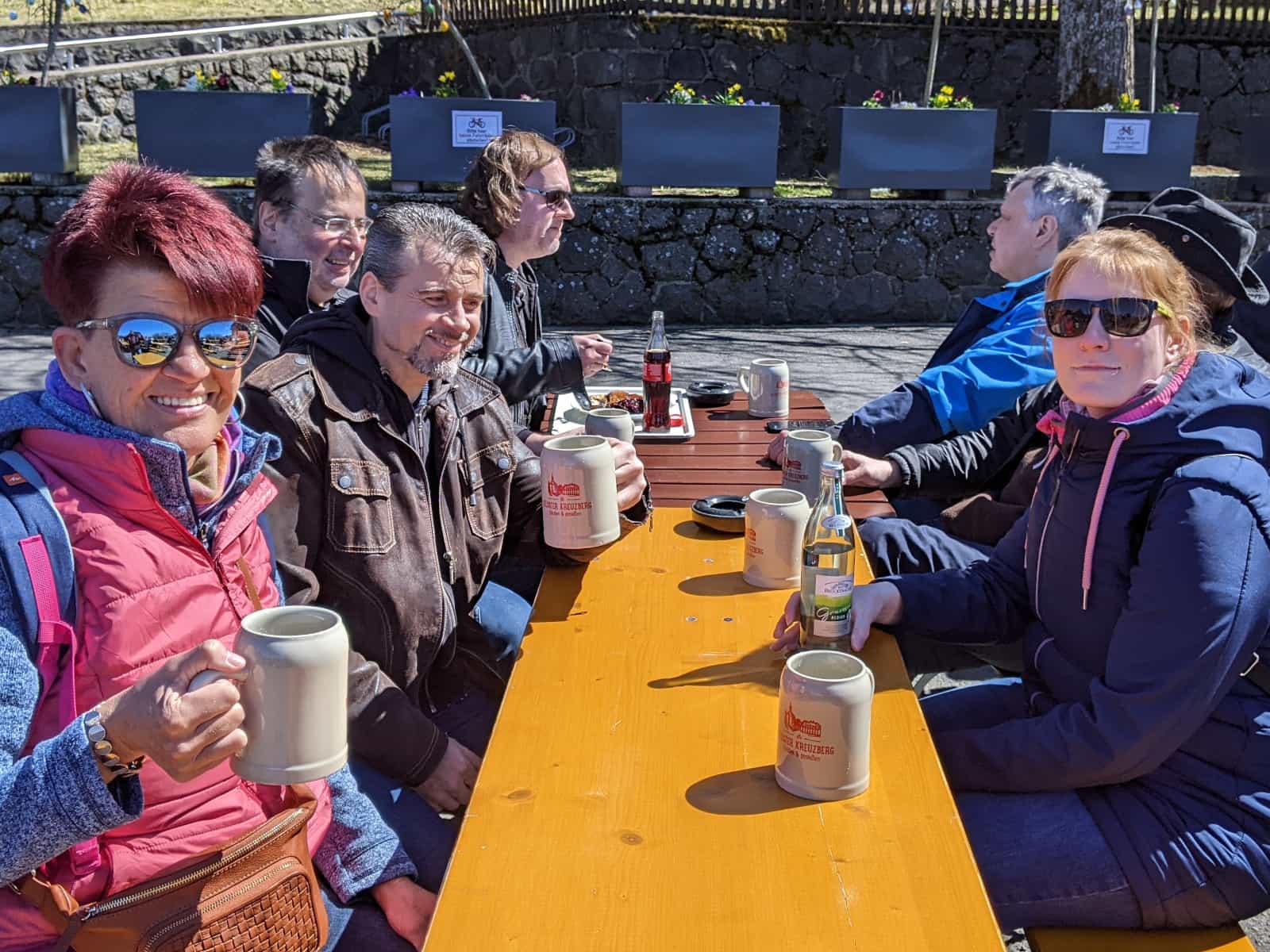 Gemütliche Runde am Biertisch im Sonnenschein auf dem Kreuzberg.