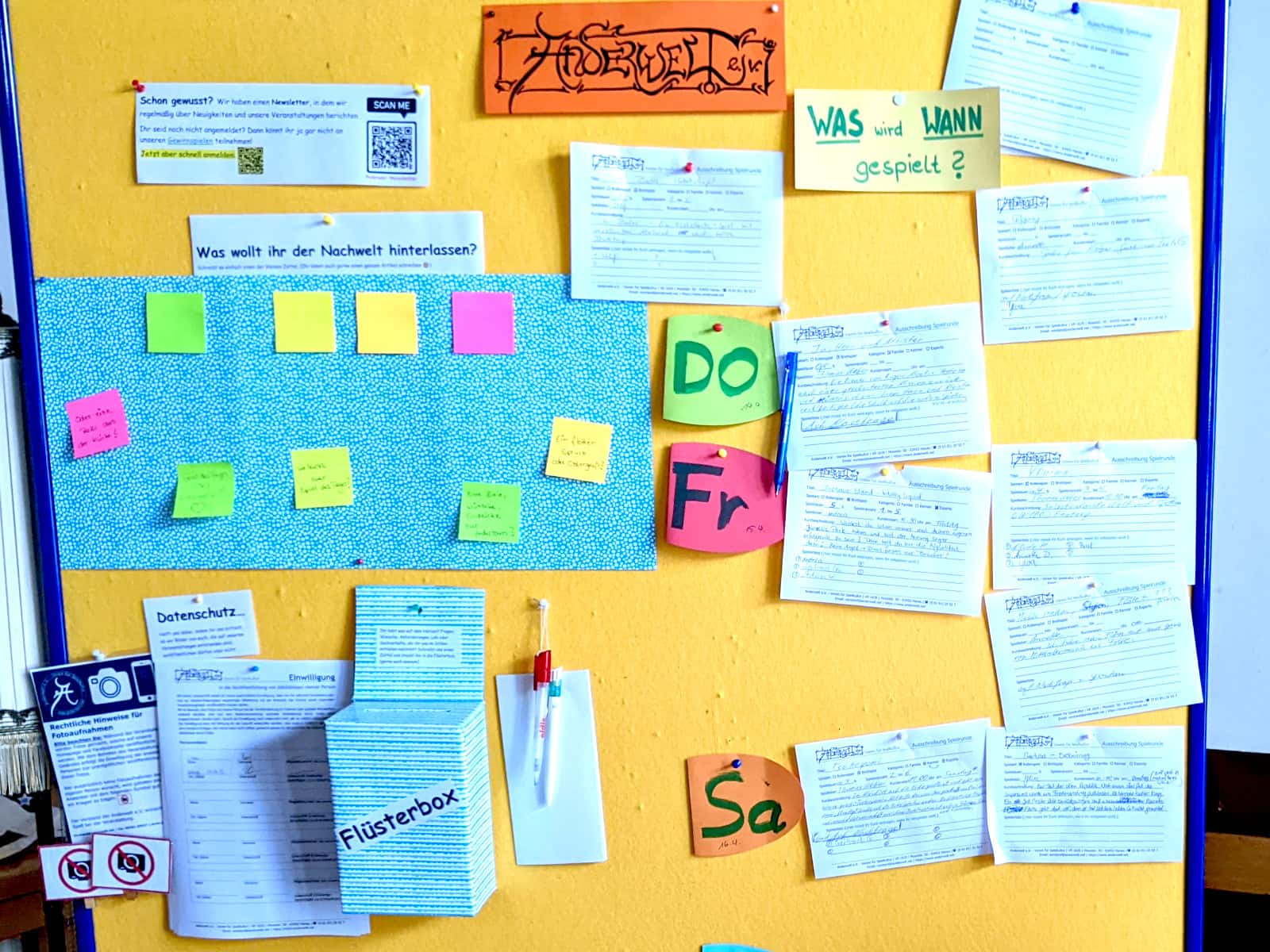 Pinnwand mit Spiele-Ausschreibungen, Flüsterbox und Bereich zum Verewigen.