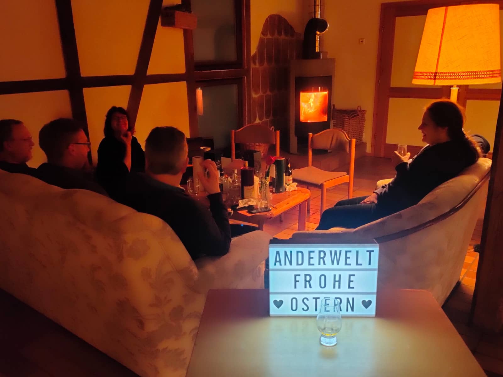 Heitere Runde beim abendlichen Whisky-Tasting vor dem Kaminfeuer.