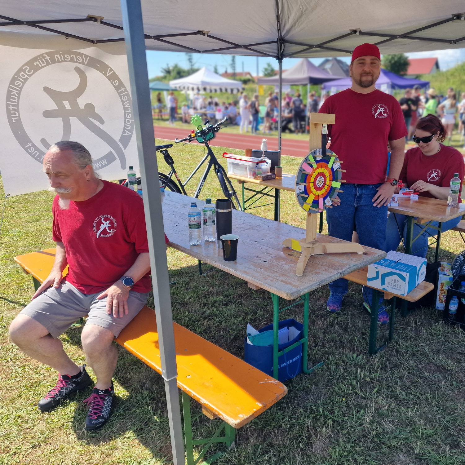 Vereinsmitglieder am Anderwelt-Stand, bereit für Spiele und Bespaßung.