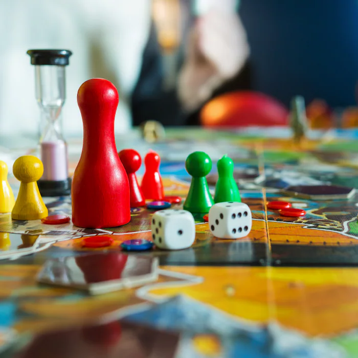  Nahaufnahme verschiedener Spiele-Meeple, Würfel und Tokens auf einem bunten Spielbrett. (Eigentum von IKEA)