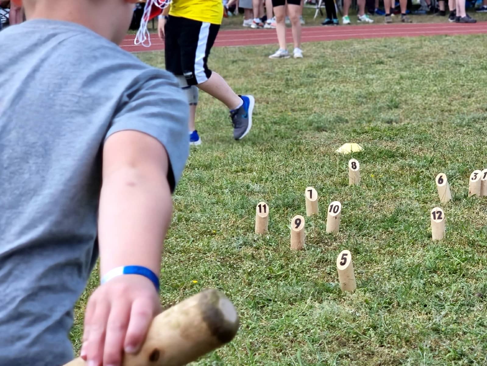 Kinder beim Mölkky spielen auf der Wiese.