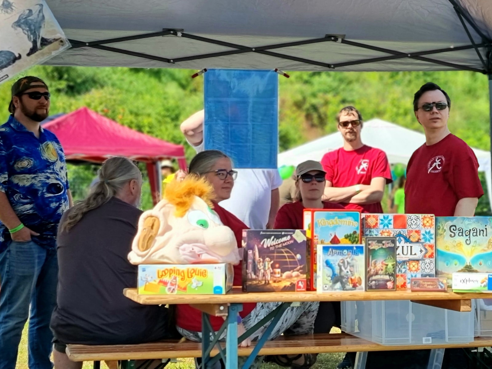 Mit einem Zelt überdachter Anderwelt-Stand mit Mitgliedern, an dem verschiedene Spiele präsentiert werden.