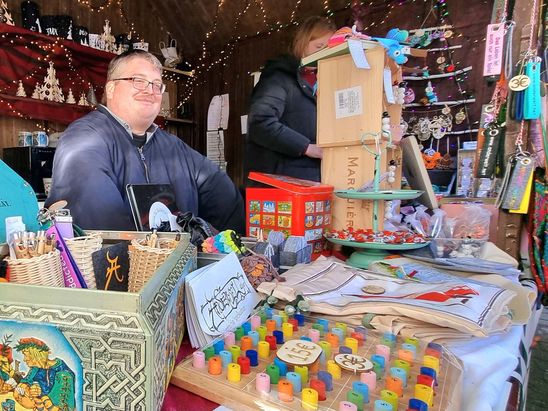 Wahrenauslage mit Anderwelt-Merch, diversem Spiel-Zubehör, Deko-Artikeln und freundlichen Verkäufern.